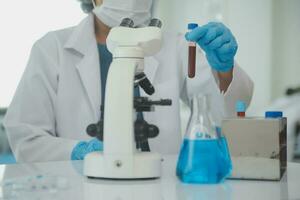 Health care researchers working in life science laboratory. Young female research scientist and senior male supervisor preparing and analyzing microscope slides in research lab. photo