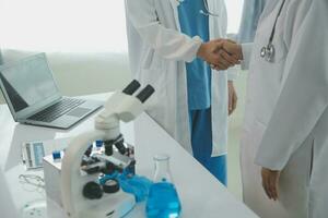 Health care researchers working in life science laboratory. Young female research scientist and senior male supervisor preparing and analyzing microscope slides in research lab. photo