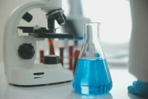 investigadores de atención médica que trabajan en el laboratorio de ciencias de la vida. joven científica investigadora y supervisora masculina senior preparando y analizando portaobjetos de microscopio en el laboratorio de investigación. foto