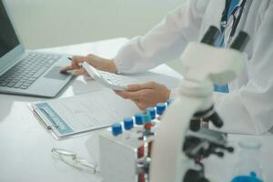 Health care researchers working in life science laboratory. Young female research scientist and senior male supervisor preparing and analyzing microscope slides in research lab. photo