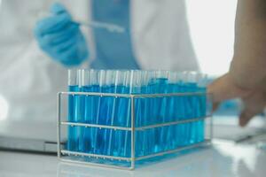 Health care researchers working in life science laboratory. Young female research scientist and senior male supervisor preparing and analyzing microscope slides in research lab. photo