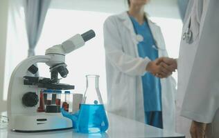 Health care researchers working in life science laboratory. Young female research scientist and senior male supervisor preparing and analyzing microscope slides in research lab. photo