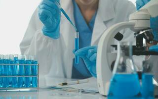 Health care researchers working in life science laboratory. Young female research scientist and senior male supervisor preparing and analyzing microscope slides in research lab. photo