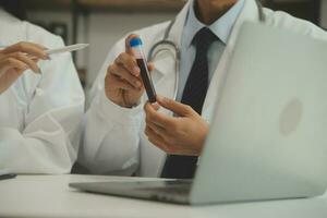 medical team having a meeting with doctors in white lab coats and surgical scrubs seated at a table discussing a patients records,success medical health care, Medicine doctor's working concept photo