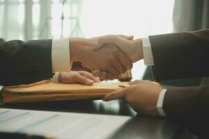 Business and lawyers discussing contract papers with brass scale on desk in office. Law, legal services, advice, justice and law concept picture with film grain effect photo