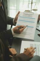 Business and lawyers discussing contract papers with brass scale on desk in office. Law, legal services, advice, justice and law concept picture with film grain effect photo