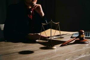 Justice and law concept.Male judge in a courtroom with the gavel, working with, computer and docking keyboard, eyeglasses, on table in morning light photo