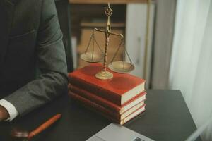 Business and lawyers discussing contract papers with brass scale on desk in office. Law, legal services, advice, justice and law concept picture with film grain effect photo