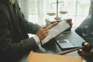 Business and lawyers discussing contract papers with brass scale on desk in office. Law, legal services, advice, justice and law concept picture with film grain effect photo