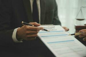 Business and lawyers discussing contract papers with brass scale on desk in office. Law, legal services, advice, justice and law concept picture with film grain effect photo