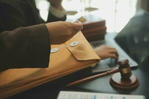 Business and lawyers discussing contract papers with brass scale on desk in office. Law, legal services, advice, justice and law concept picture with film grain effect photo