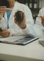 medical team having a meeting with doctors in white lab coats and surgical scrubs seated at a table discussing a patients records,success medical health care, Medicine doctor's working concept photo