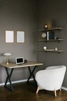 Workplace in a modern Scandinavian room. Table, armchair, laptop, shelves with decor photo