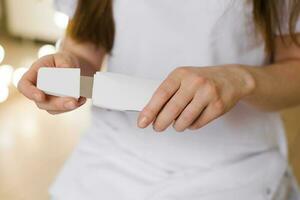 Close-up of a cosmetologist woman opening a device for ultrasonic facial cleansing photo