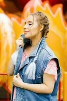 Sensual Caucasian young woman with blue pigtails with bright makeup in an amusement park photo