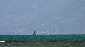 Kitesurfen, Kitesurfen Kiter und Kiteboarder ist gezogen über Meer Wasser durch ein Wind Leistung Drachen video