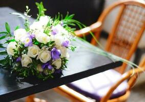 delicado Boda blanco y púrpura ramo de flores de el novia en el mesa en el café foto