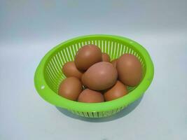 A group of eggs in green basket isolated on white background photo