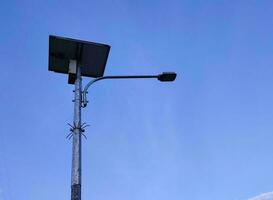 Street light or street lamp or road light using solar panels with the sky in the background photo