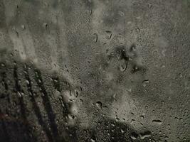 Abstract background of drops of water flow down at windshield. photo