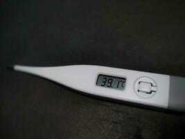 Selective focus digital thermometer. Human body temperature 39.1 degrees celsius on display. photo