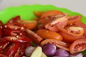 Close up typical Indonesian kitchen spices consist of pieces tomatoes, onion, garlic, and chilies photo