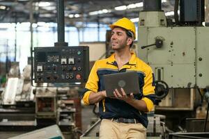 Caucasian engineer using a laptop in a factory. man working in plastics factory. photo