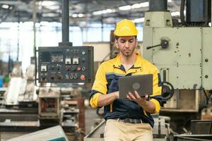 Caucasian engineer using a laptop in a factory. man working in plastics factory. photo