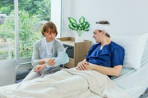 The patient has a headache while lying in the hospital room with Gauze Bandage Wrapped Around Head. photo