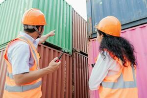 Team of logistics engineers, men and women in reflective jackets stand outside large commercial port. Containers in Export-Import Business and Logistics photo