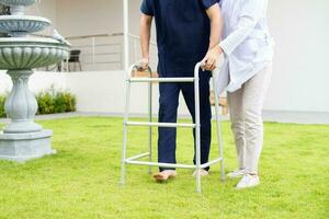 Patient using mobility walker in garden at sanatorium center photo