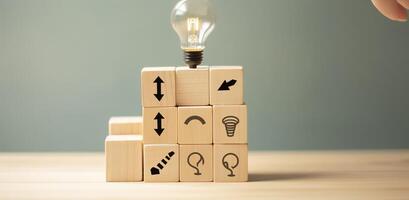 Creative idea, solution and innovation concept. Idea generation for business development. Wooden cube blocks with light bulb and cycle icons on clean background and copy space. photo