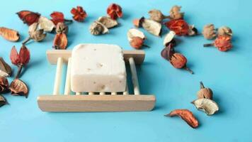 natural soap bar on a wooden tray surrounded by dried flowers video