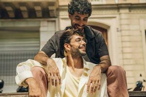 men sitting on a bench in the city kissing ang huging each other photo