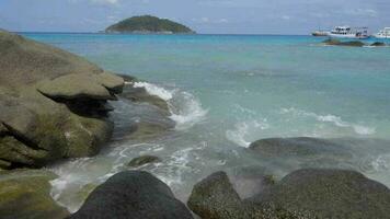turchese onde lanciato su il rocce, spiaggia di KOH miang isola, similan isole video