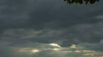 Gewitterwolken und Strahlen von das Sonne Über das Meer. das Sonne Strahlen scheinen durch das dunkel Sturm Wolken video