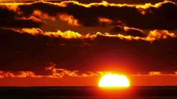 Scenic close up view of sun setting beyond the horizon over the sea. video