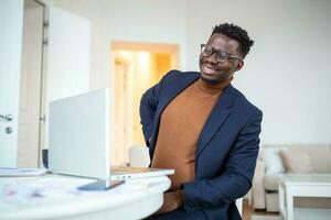 Businessman working sitting at desk feels unhealthy suffers from lower back pain. Damage of intervertebral discs, spinal joints, compression of nerve roots caused by wrong posture and sedentary work. photo