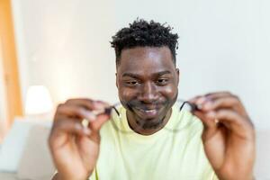 African man in glasses rubs his eyes, suffering from tired eyes, ocular diseases concept photo