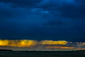 a large field with a sky filled with clouds photo