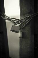 a black and white photo of a padlock on a chain