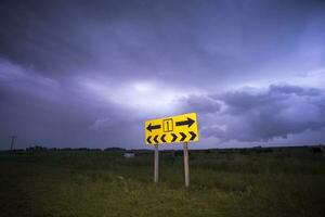 a yellow sign with a yellow arrow pointing to the left photo