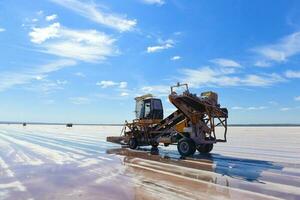 a large machine is working on a large field photo