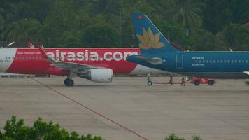 PHUKET, THAILAND NOVEMBER 26, 2019 - AirAsia Airbus A320 HS BBG pushing back before departure. View from the top floor of the hotel near airport video