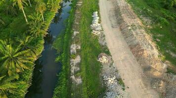 Scenic dirt road winding alongside river from an aerial perspective video
