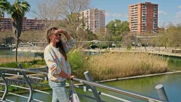 une femme permanent sur une pont à la recherche à le caméra video