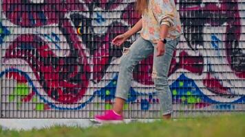 uma mulher posando dentro frente do vibrante coberto de graffiti parede video