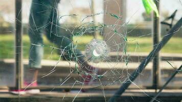 A broken glass window with a silhouette of a person in the background video