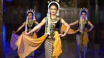 een groep van Indonesisch dansers dans samen met blauw verlichting Aan de stadium video