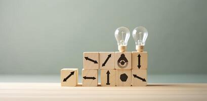 Creative idea, solution and innovation concept. Idea generation for business development. Wooden cube blocks with light bulb and cycle icons on clean background and copy space. photo